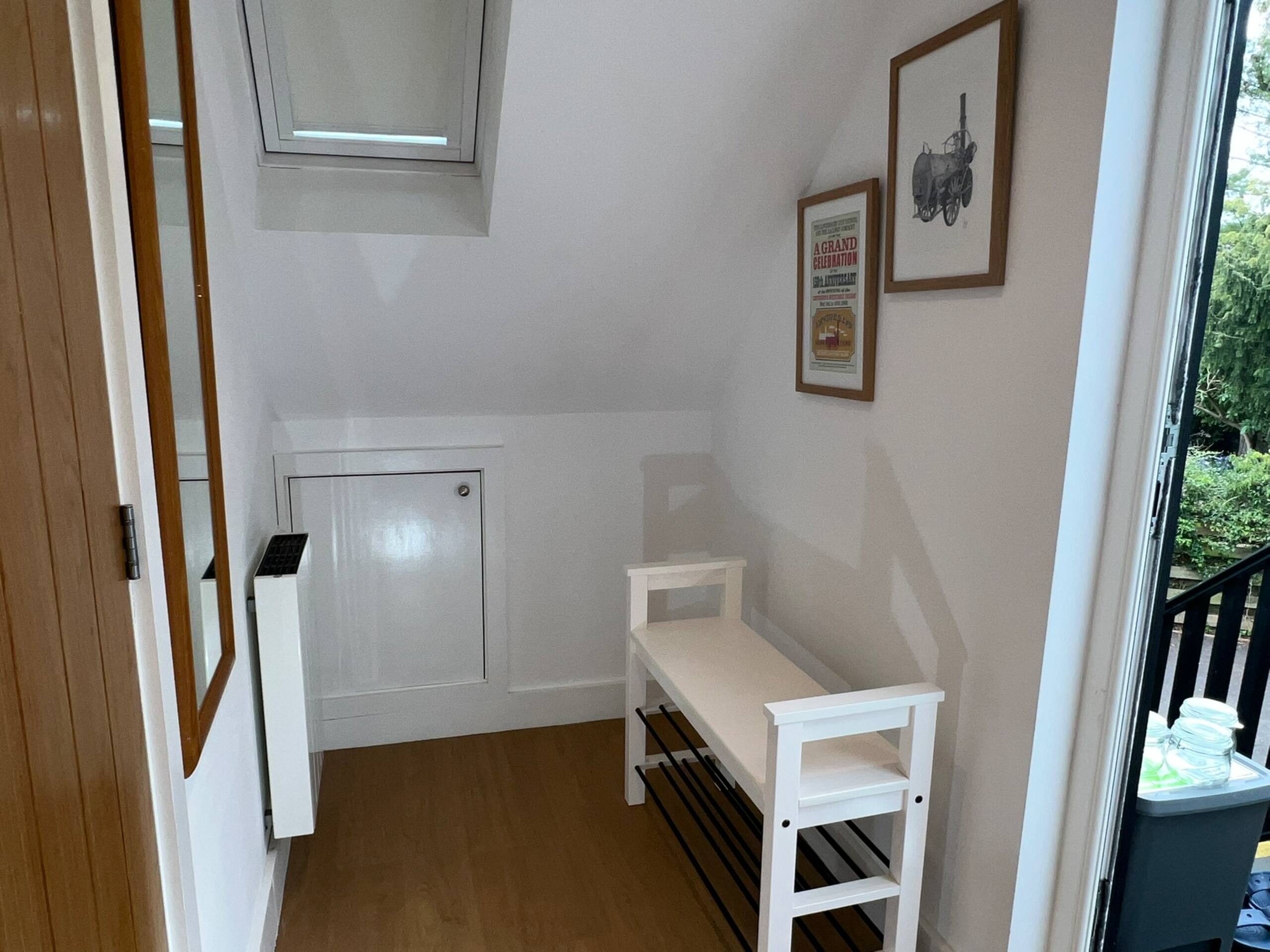 Entrance lobby with storage bench, framed art and skylight
